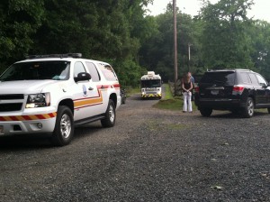 Anne Arundel and Howard County fire and EMS vehicles leaving Camp Letts as a worried camper's parent looks on.