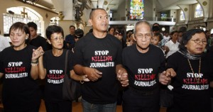 Family members of journalists killed in the Maguindanao massacre hold hands while singing "Our Father" during a funeral in General Santos city in southern Philippines December 4, 2009. Philippine soldiers using metal detectors, sniffer dogs and an excavator unearthed more than a dozen crates of bullets Friday in the mansion of a local mayor linked to last week's massacre of 57 people, a spokesman said. REUTERS/Erik de Castro (PHILIPPINES CONFLICT CRIME LAW) COURTESY: Committee to Protect Journalists.